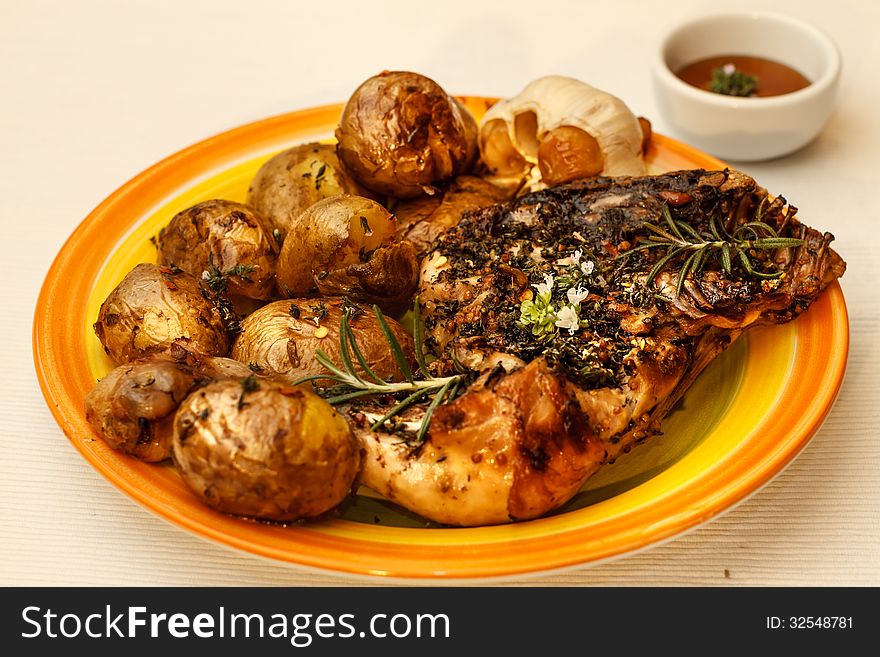 Roasted chicken leg with potatoes and herbs. Roasted chicken leg with potatoes and herbs