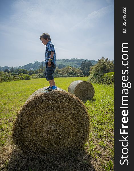 Boy On Round Hay Bale