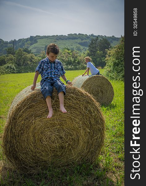 Boys on round hay bales