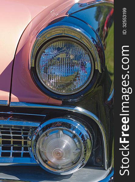 Closeup of a Vintage Pink Classic American Car headlights. Closeup of a Vintage Pink Classic American Car headlights.