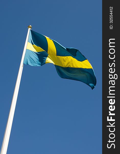 Picture of Swedish flag waving in the wind, on a blue sky  Picture of Swedish flag waving in the wind, on a blue sky