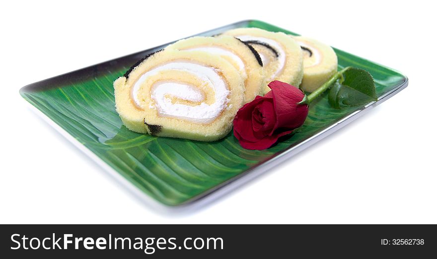 Spiral Cake with red rose on a plate. Spiral Cake with red rose on a plate