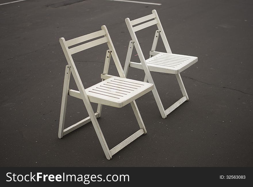 Two white folding chairs