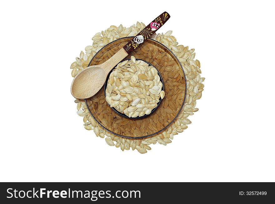 Plate of filled with pumpkin seeds stands on pumpkin seeds