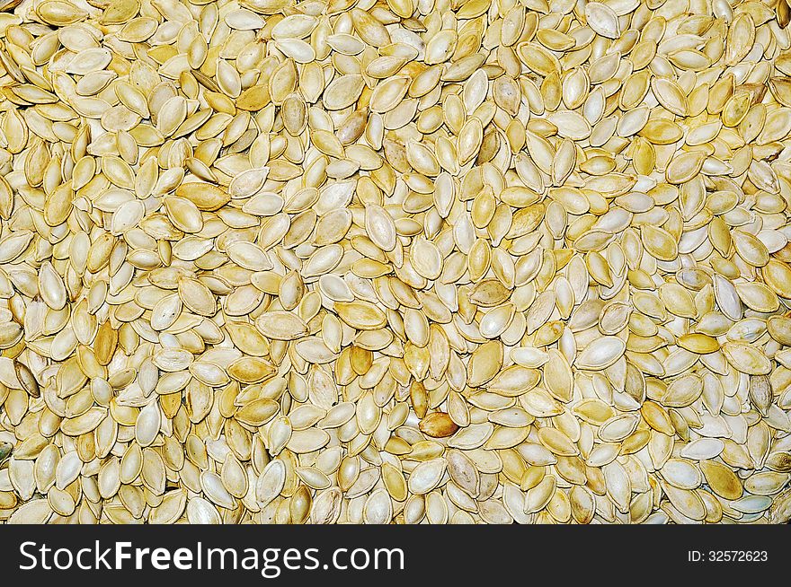 Plate of filled with pumpkin seeds stands on pumpkin seeds