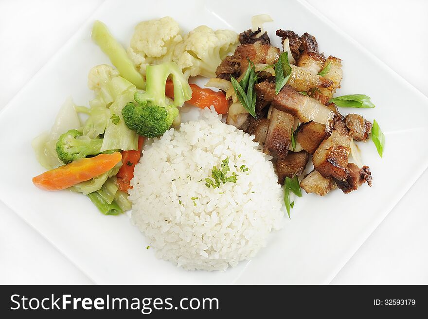 Fried pork chop, steamed vegetables and rice shot on a plate on a white background. Fried pork chop, steamed vegetables and rice shot on a plate on a white background