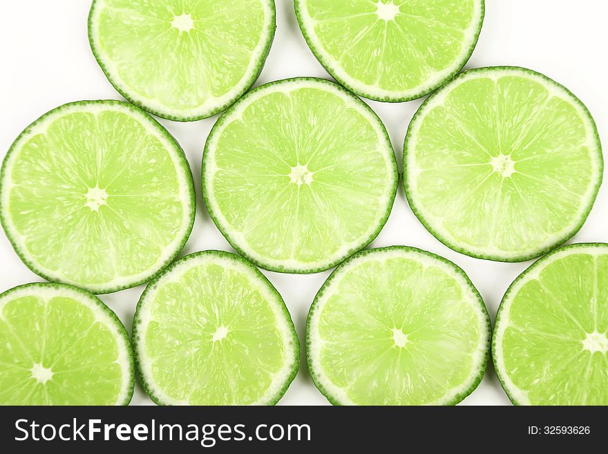 Lime slices neatly arranged on a white background