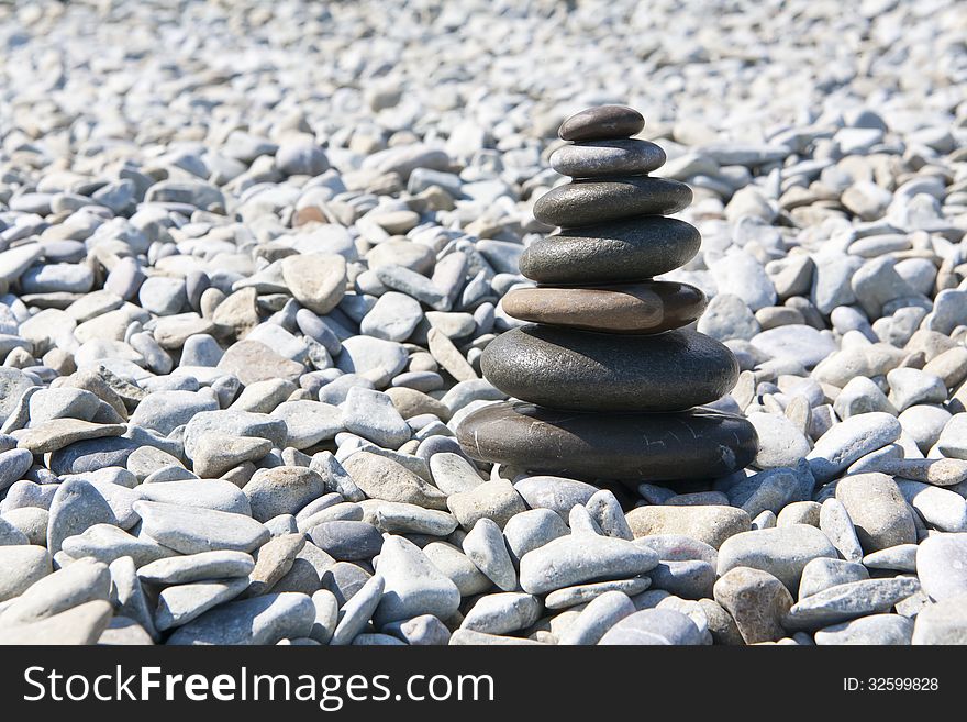 Pyramid of pebbles on the beach background