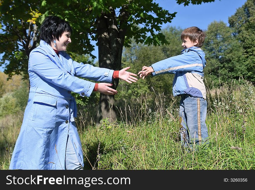 Young mother and her son offering hands to each other