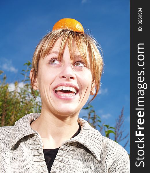 Girl in nature with orange on head. Girl in nature with orange on head