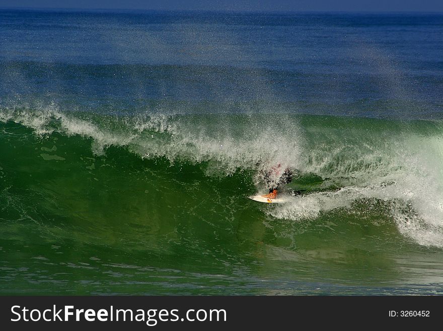 An image of a surfer doing a maneuver in the barrel. An image of a surfer doing a maneuver in the barrel.