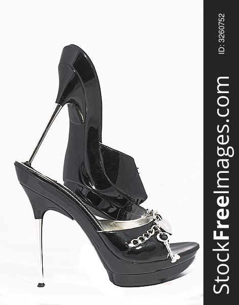 Black shoes from a varnish leather with chains and ornaments of silver on a sharp thin steel heel