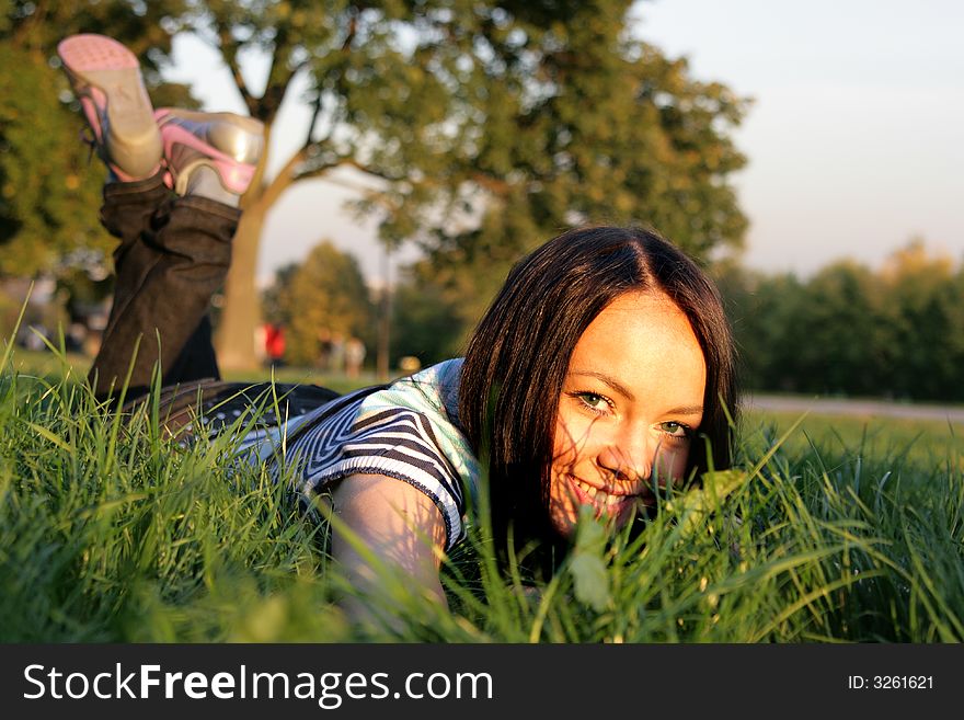 Young happy woman  lying on the grass at evenings. Young happy woman  lying on the grass at evenings