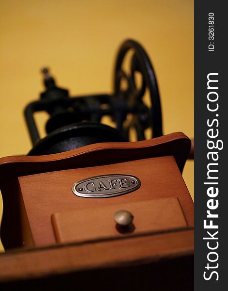 An antique coffee grinder with a metal CAFE label.