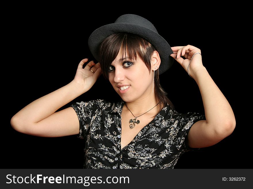 The young smiling girl in a hat, on a black background. The young smiling girl in a hat, on a black background