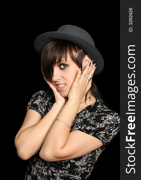 The young smiling girl in a hat, on a black background