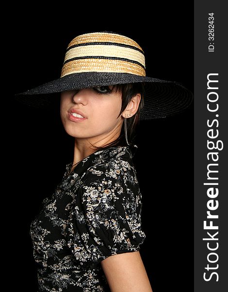The young girl in a hat, on a black background. The young girl in a hat, on a black background