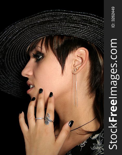 The young beautiful girl in a straw hat, on a black background. The young beautiful girl in a straw hat, on a black background