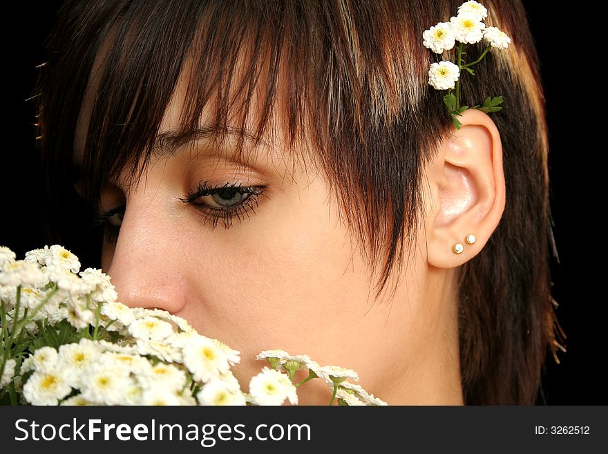 The young beautiful girl with flowers, isolated on a black background. The young beautiful girl with flowers, isolated on a black background