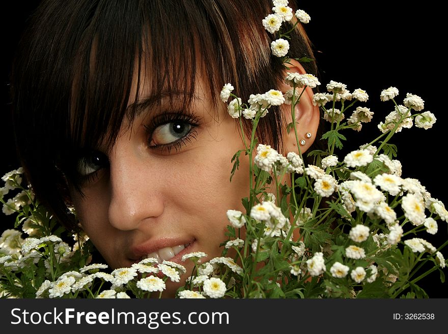 The young beautiful girl with flowers, isolated on a black background. The young beautiful girl with flowers, isolated on a black background