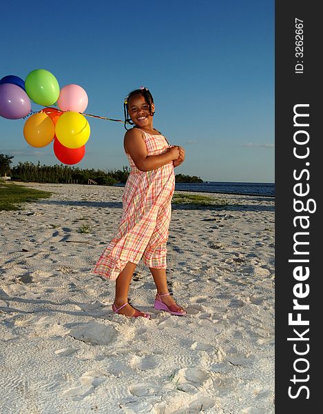 A smiling girl with ballons on the beach. A smiling girl with ballons on the beach