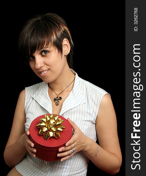 The young girl holds a box with a gift, isolated on black background