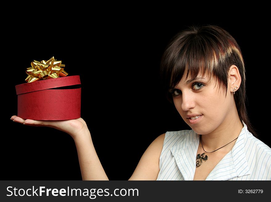 The young girl holds a box with a gift, isolated on black background