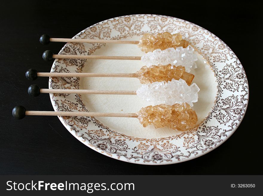 White and caramel Sugar crystals in an antique plate