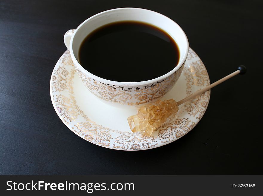 Coffee in an antique cup with a sugar crystal. Coffee in an antique cup with a sugar crystal