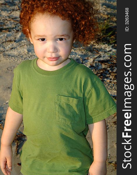 Cute multi-racial toddler with curly red hair at beach. Cute multi-racial toddler with curly red hair at beach