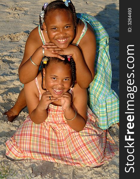 Two african american sisters posing outside on a beach. Two african american sisters posing outside on a beach