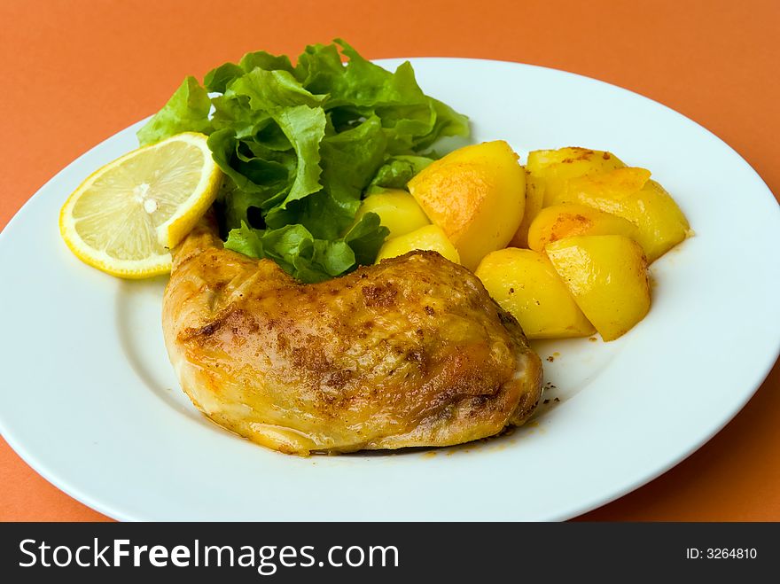 Roasted chicken legs with potatoes and salad.