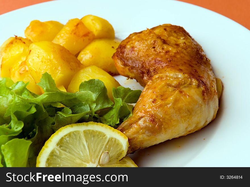 Roasted chicken legs with potatoes and salad.