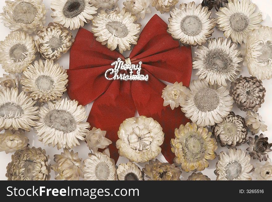 Red christmas bow over sepia flowers background. Red christmas bow over sepia flowers background