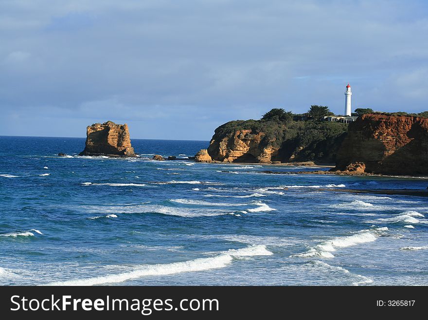 The split point lighthouse from far away with waves on a sunny day. The split point lighthouse from far away with waves on a sunny day