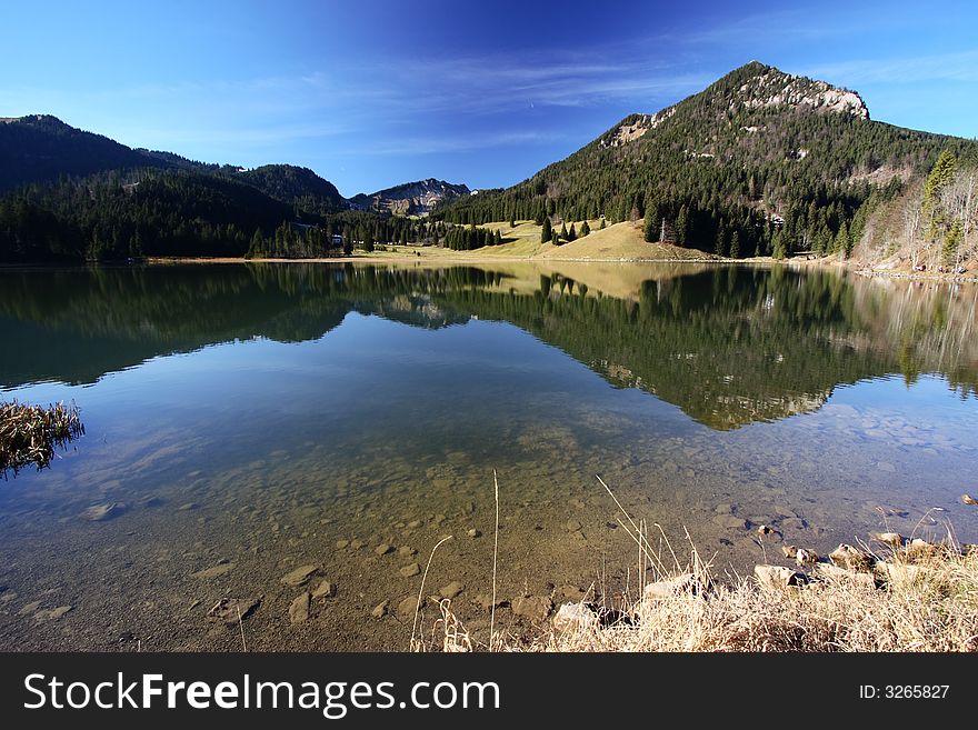 Clear lake in mountains with a mirror-flat surface. Clear lake in mountains with a mirror-flat surface