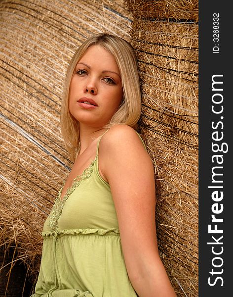 Portrait of attractive blonde leaning on hay bale. Portrait of attractive blonde leaning on hay bale.