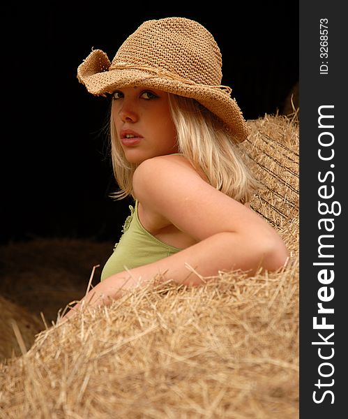 Portrait of attractive blonde posing by hay bales. Portrait of attractive blonde posing by hay bales.