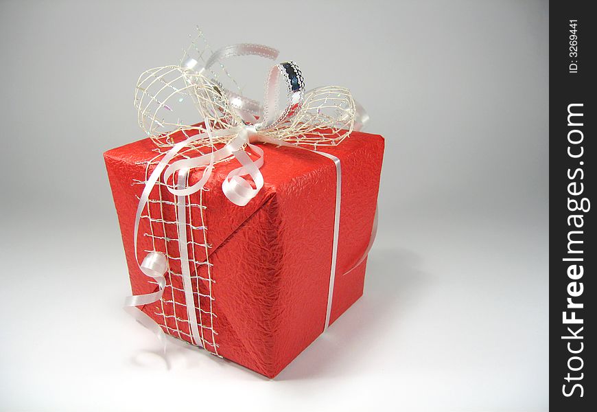 Gift in a red box with a bow on a white background