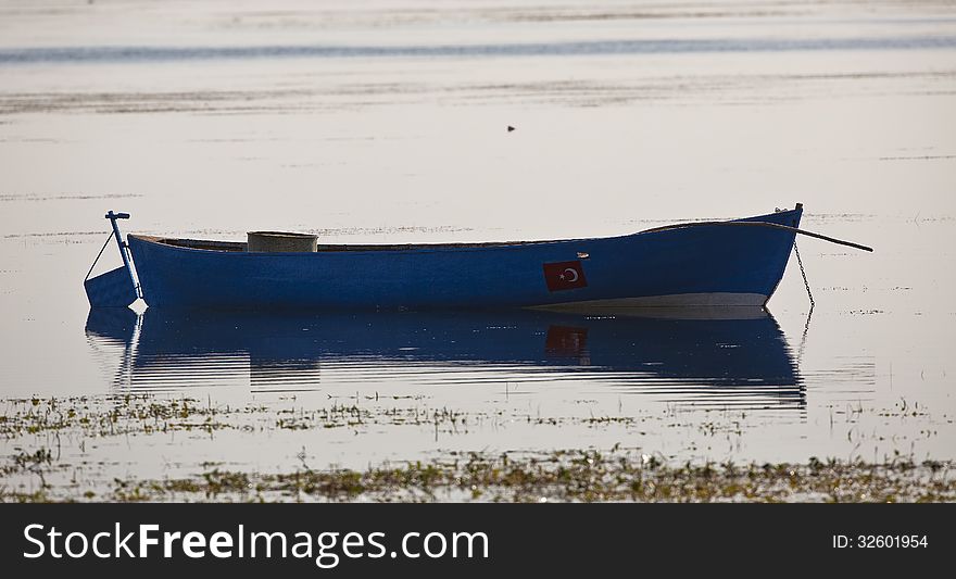 A blue empty boat floating on the lake. A blue empty boat floating on the lake
