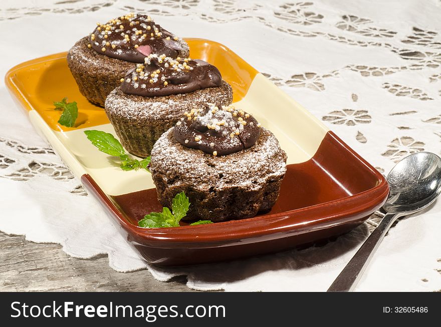 Diet chocolate cupcakes on yeliow rectangular plate with spoon