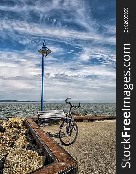 Bicycle on a quay with a lamppost on nice sunny afternoon