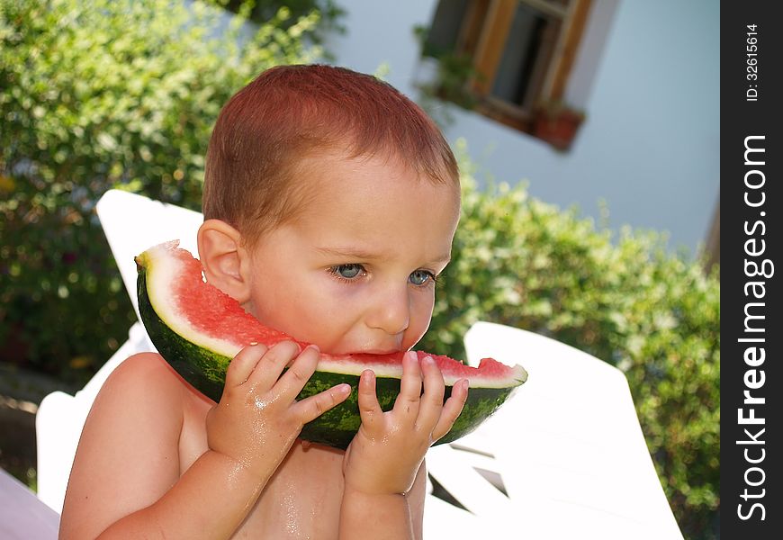 Baby eat watermelon in village house garden. Baby eat watermelon in village house garden
