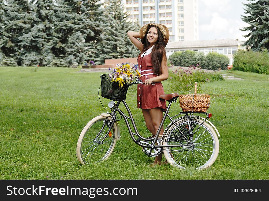 Fashion portrait of young pretty woman with bicycle and flowers