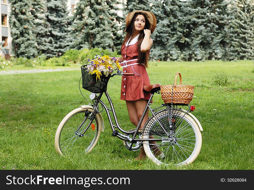 Fashion portrait of young pretty woman with bicycle and flowers