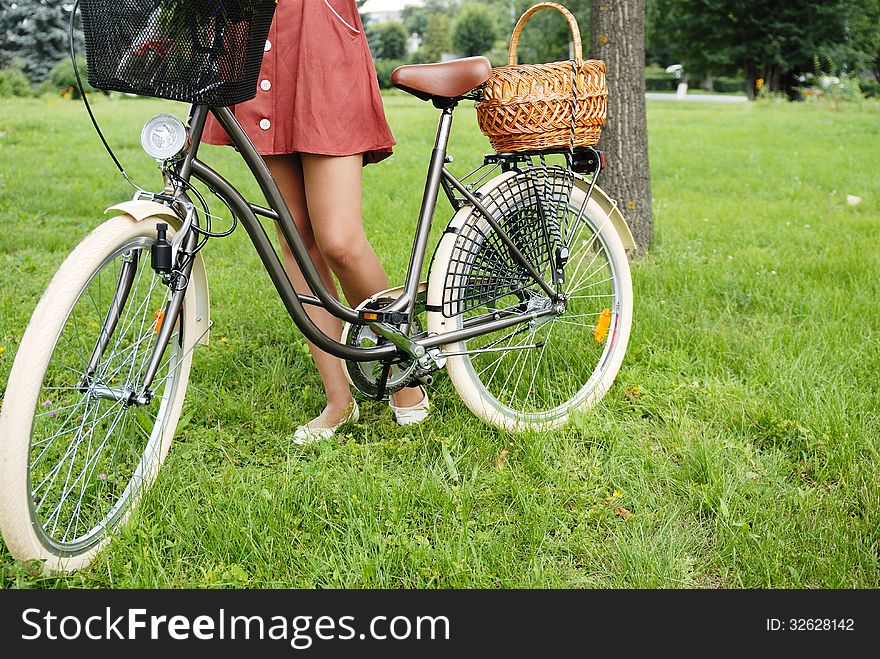 Fashion portrait of young pretty woman with bicycle and flowers