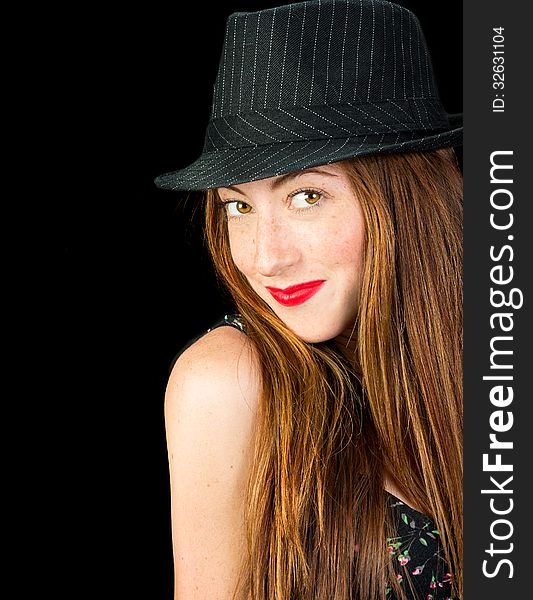 Beautiful young woman with hazel eyes and gorgeous long red hair wearing a pinstriped fedora smiling. Beautiful young woman with hazel eyes and gorgeous long red hair wearing a pinstriped fedora smiling