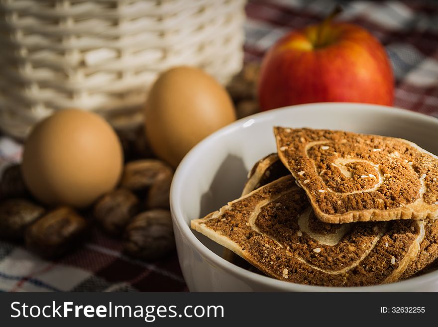 Cookies, apple and eggs with basket on the cloth. Cookies, apple and eggs with basket on the cloth