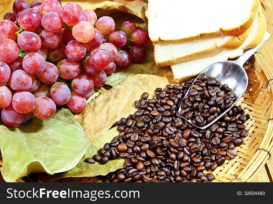 Grapes with coffee beans on basket background