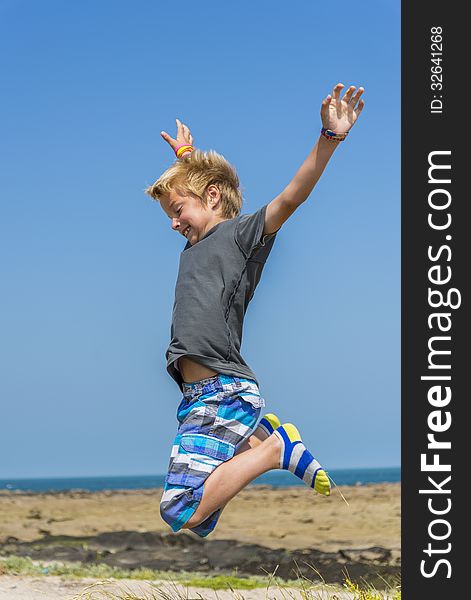 Boy jumping for joy near the sea. Boy jumping for joy near the sea